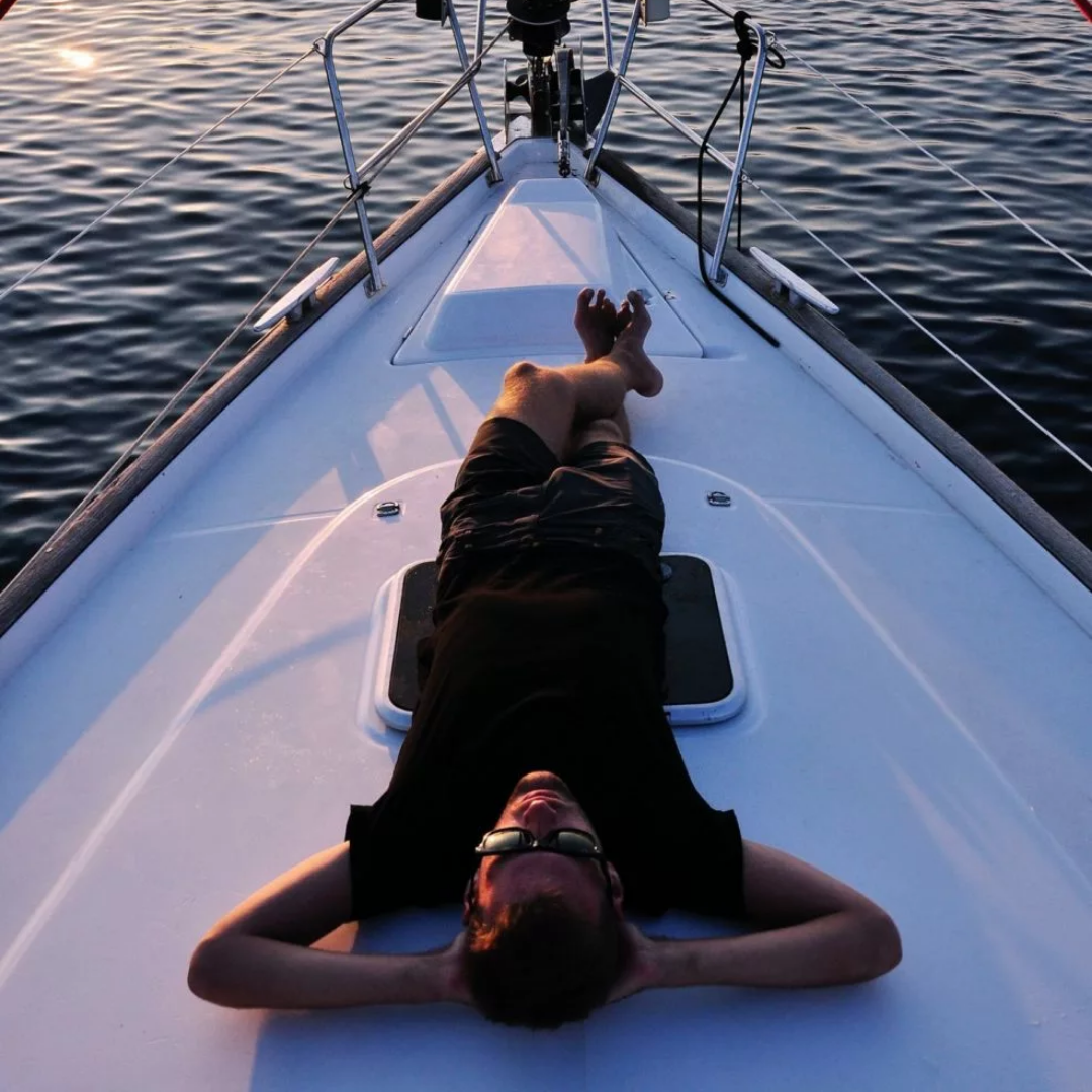 man laying down on a boat in the water